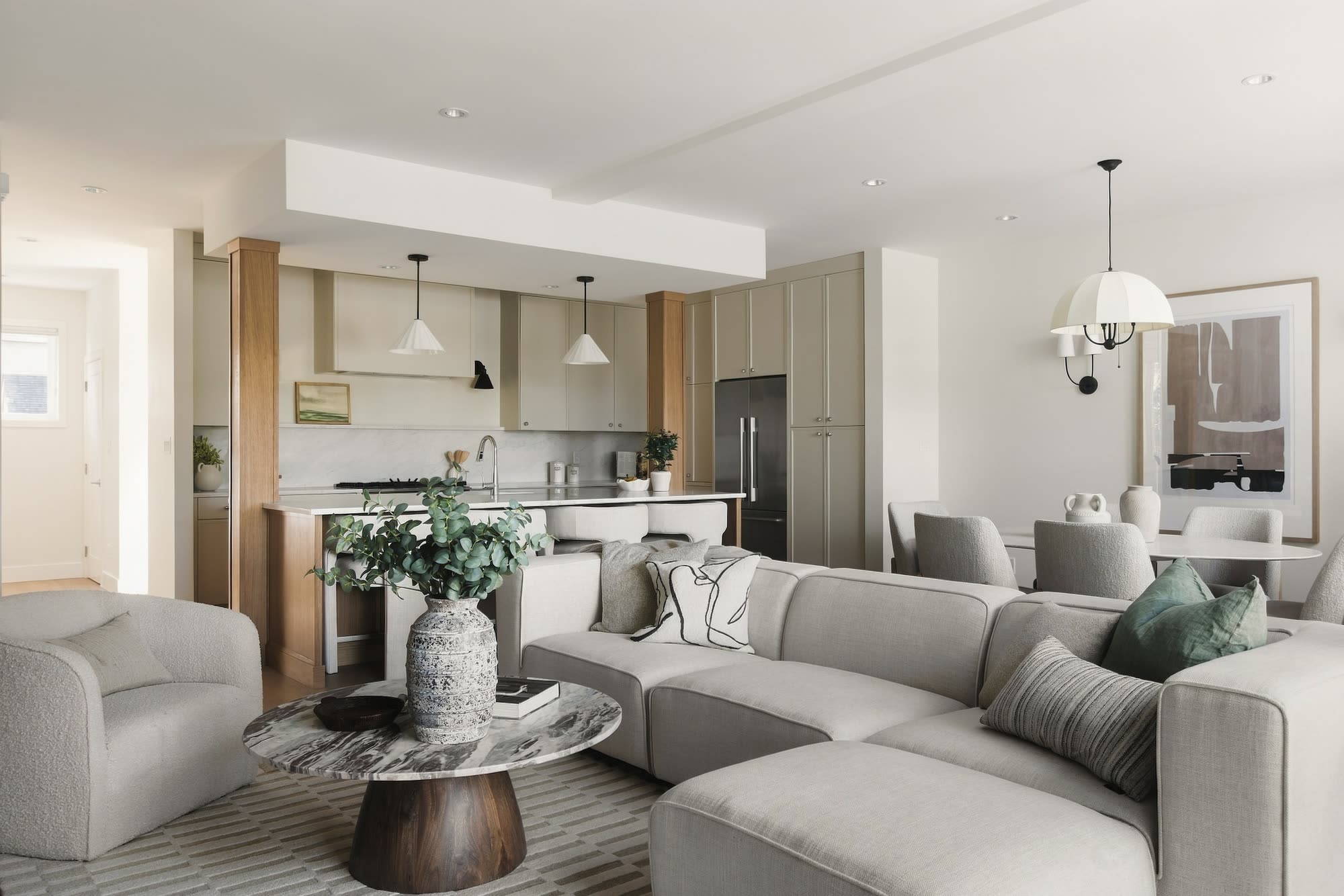 From the living room through to the kitchen, with oak columns and white cone pendants