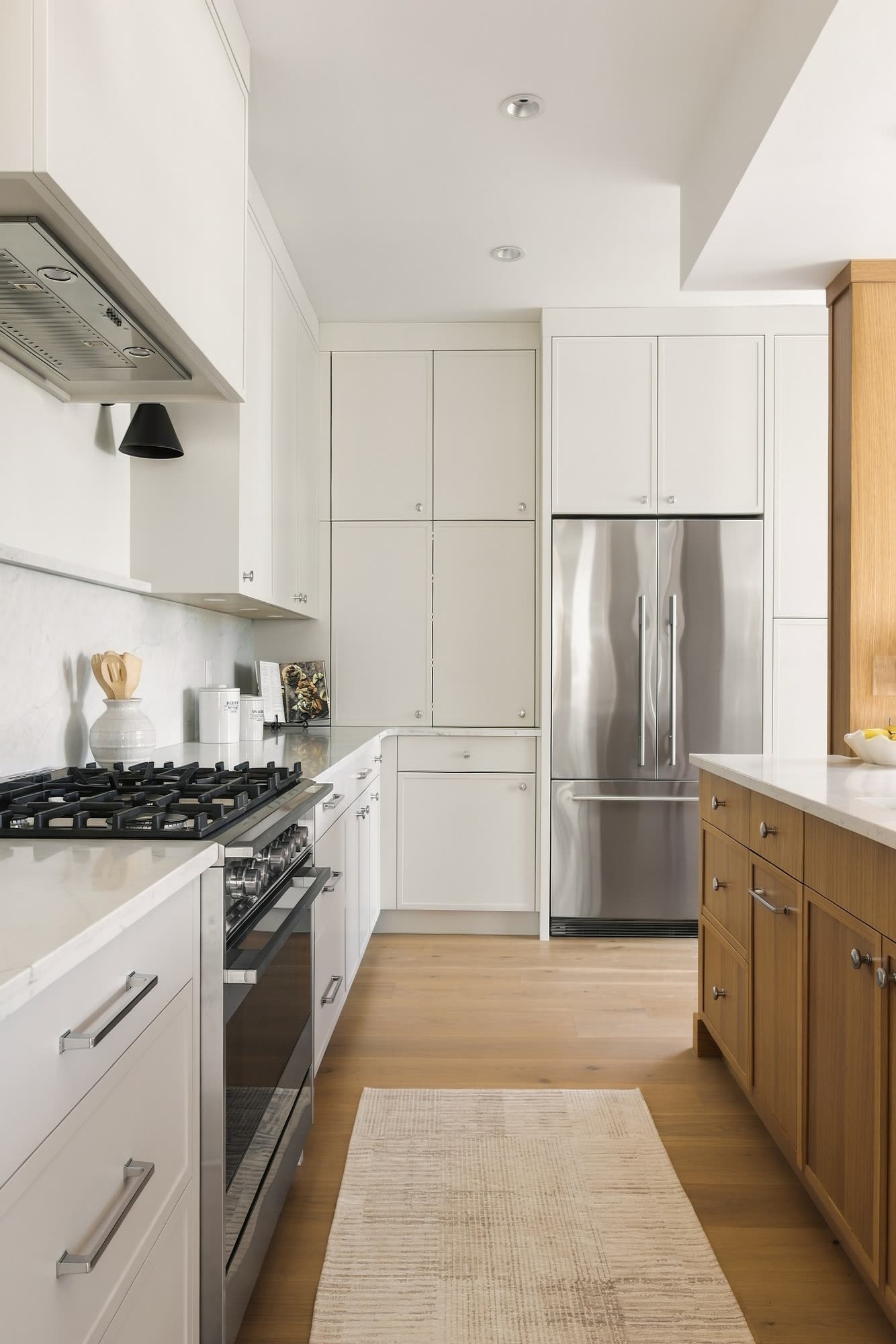 The range side of the kitchen, with a tall pantry and the fridge at the end
