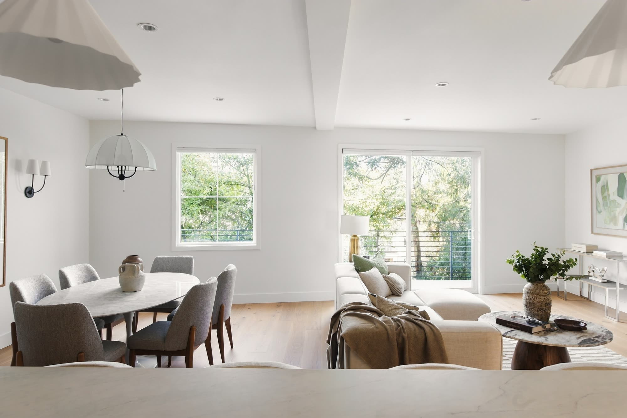 The dining table by the window, with the living room beyond