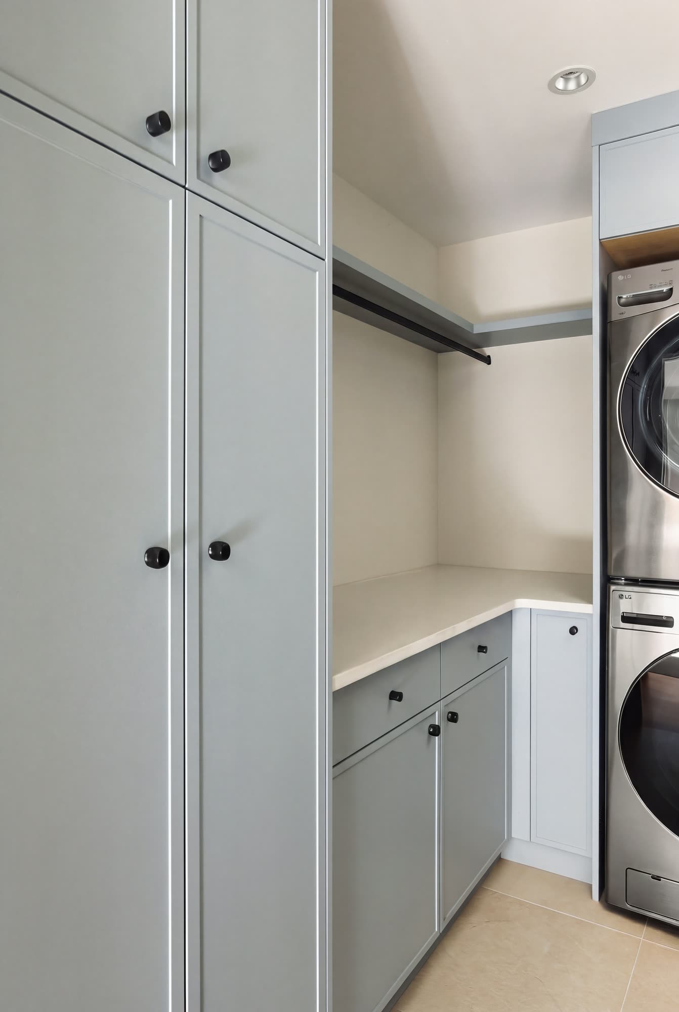 Pale blue cabinets and hanging space beside the laundry