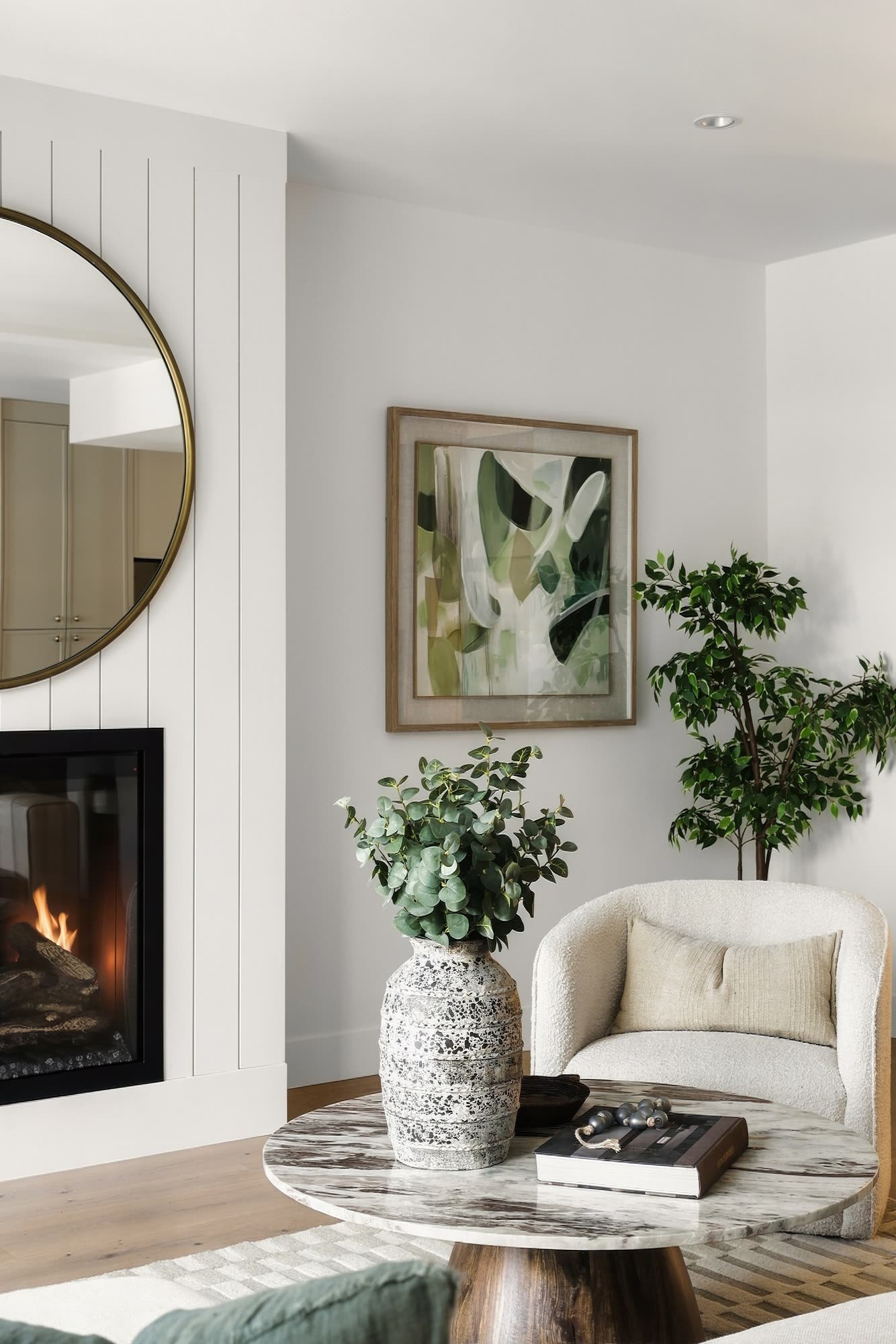 The fireplace corner, with a round brass mirror and an armchair