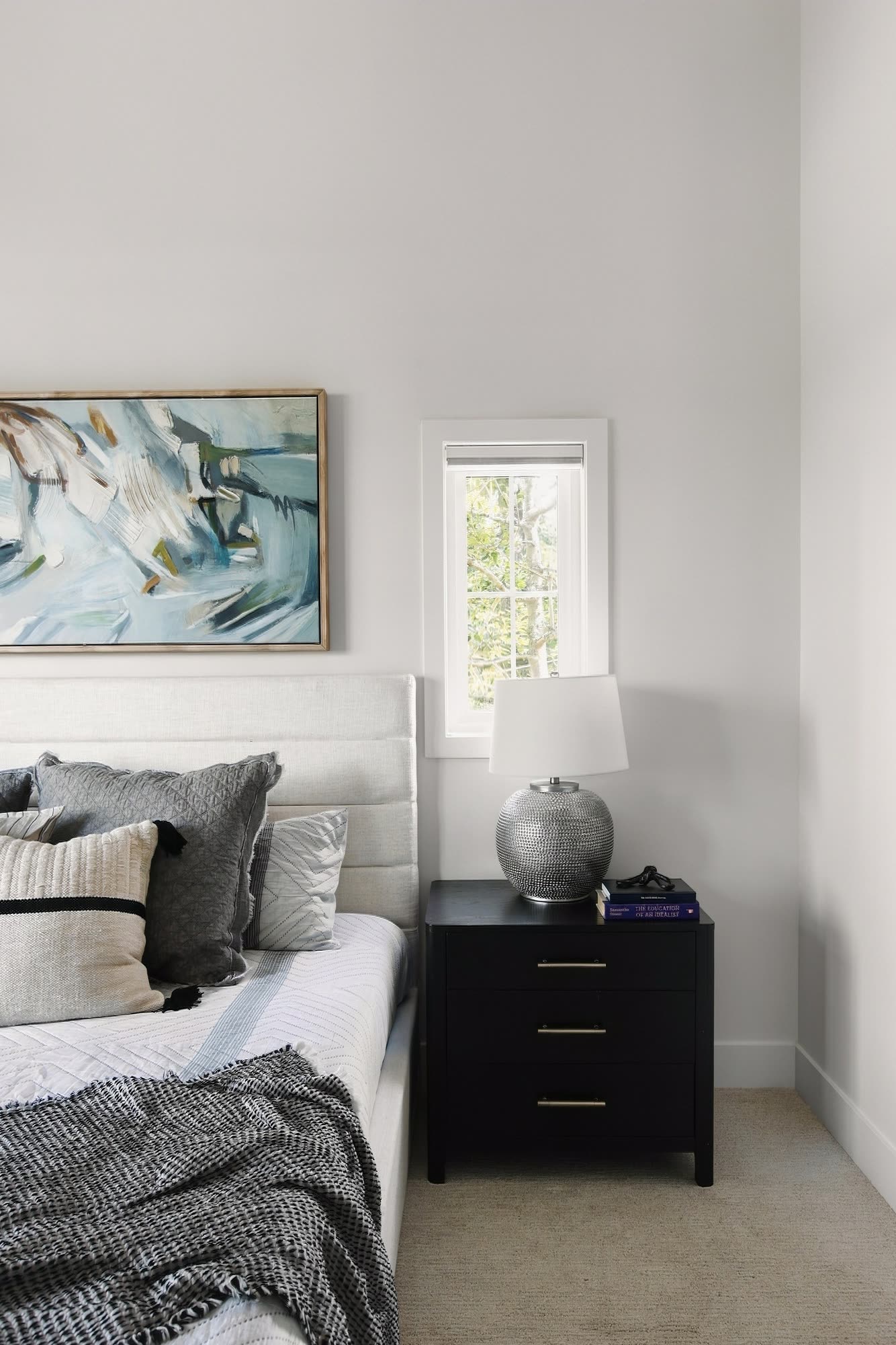 A bedside table and lamp in the primary bedroom