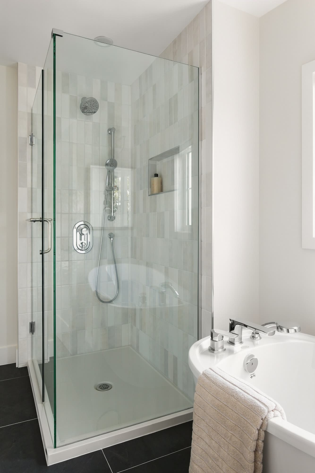 The ensuite's glass shower beside the freestanding tub