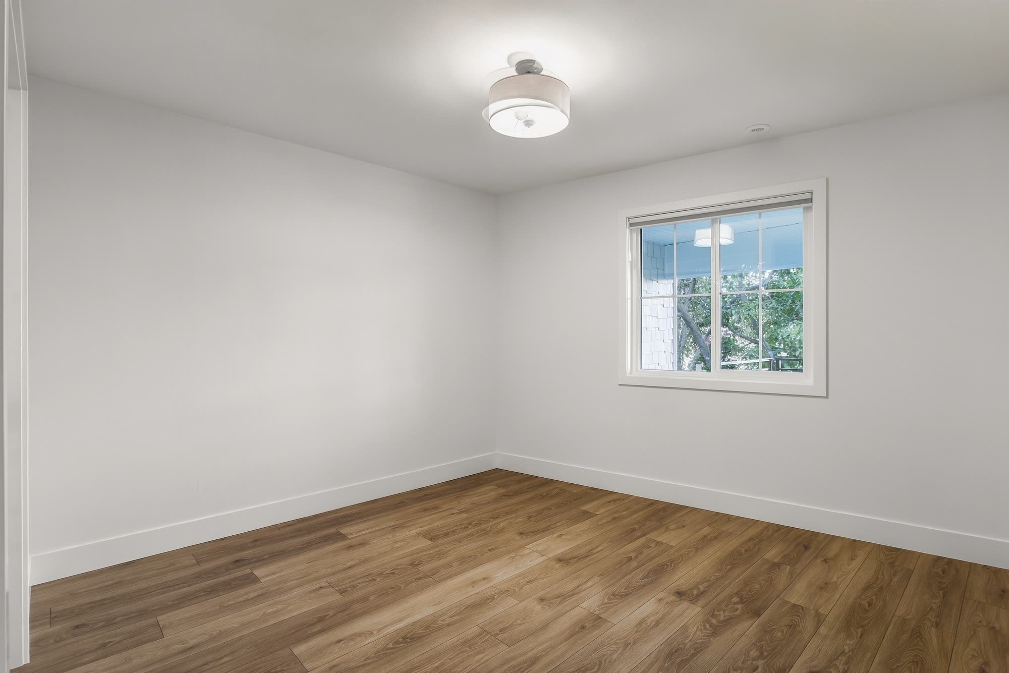 The downstairs bedroom, empty, with a window