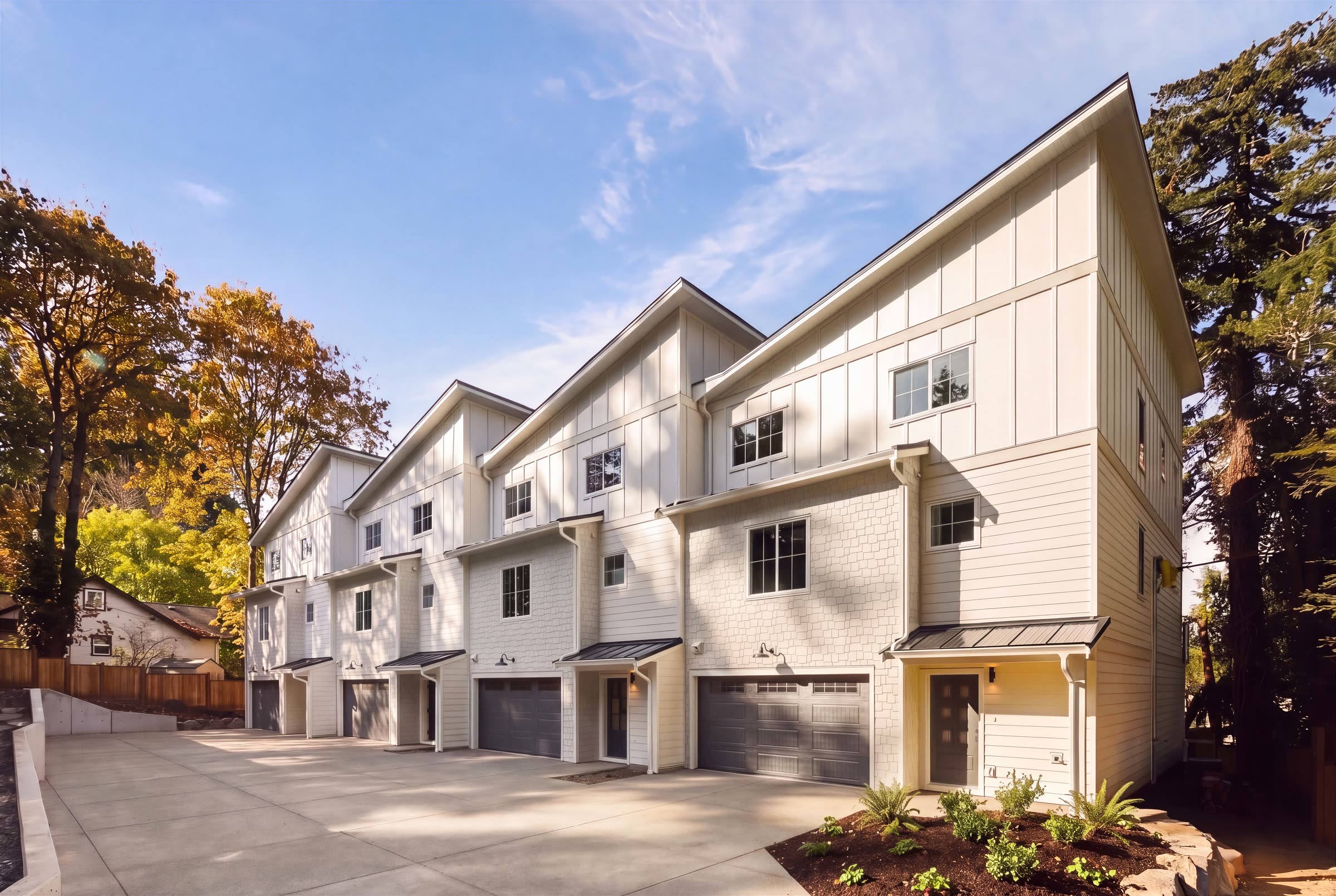 The four townhomes from the lane in afternoon sun; the planned landscaping has been added digitally